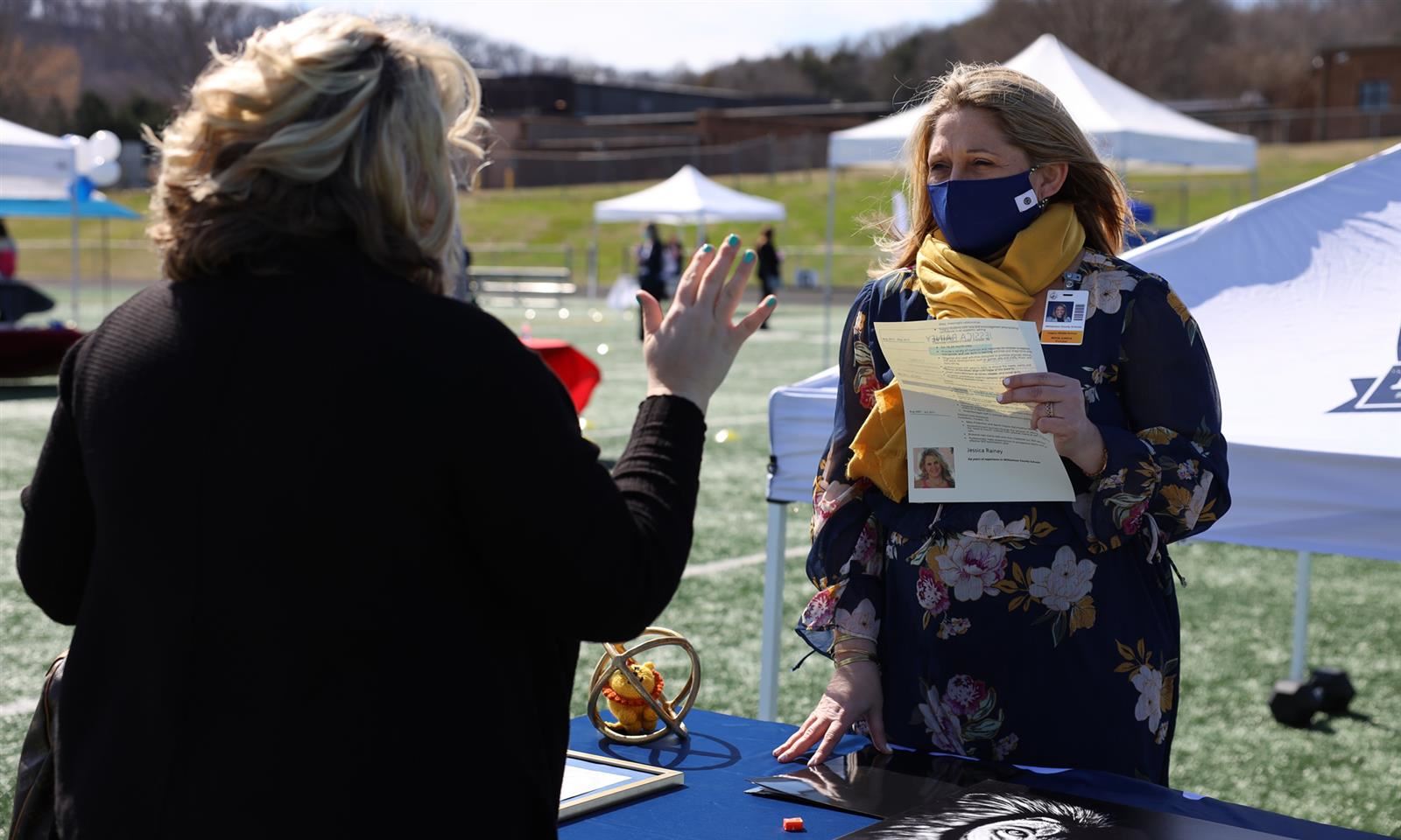 A woman talks to a school principal
